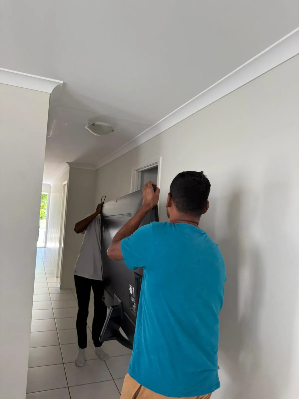Movers handling a large furniture item inside a home