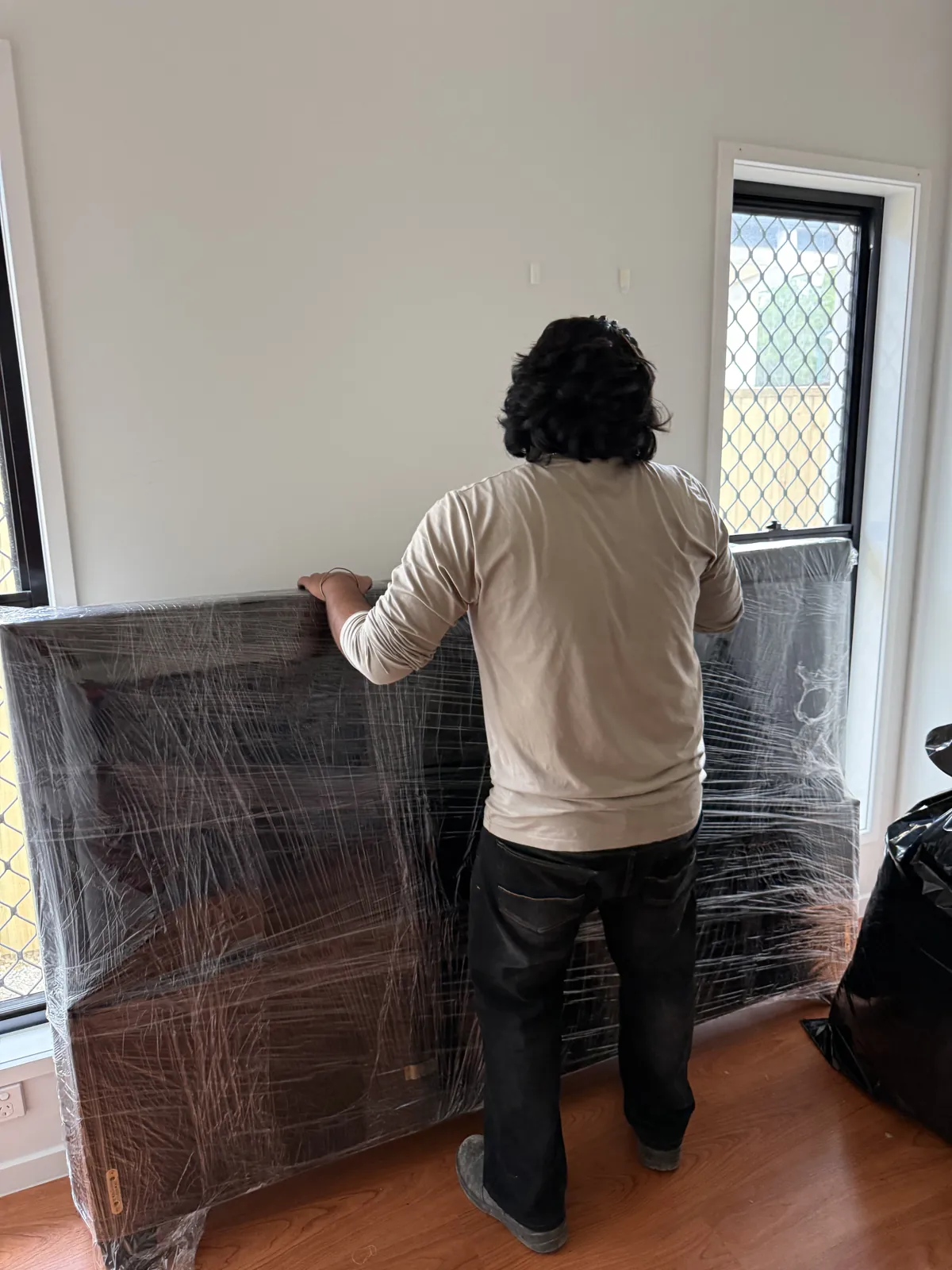 Wrapped furniture being moved through a doorway